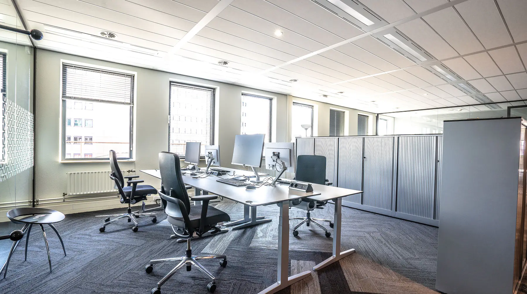 Kantoorruimte met bureaus, stoelen en kasten die leeggehaald moet worden